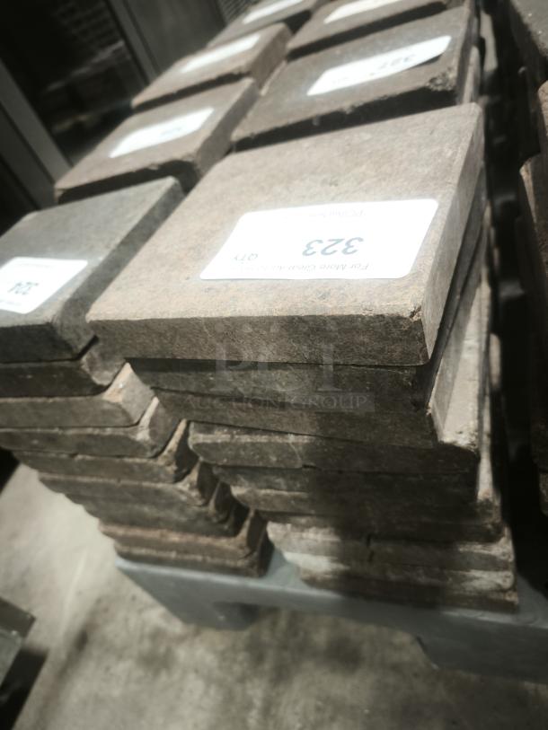 NSF certified volcanic granite slabs for cooking, stacked neatly. Tags indicate product specifications and certification details.