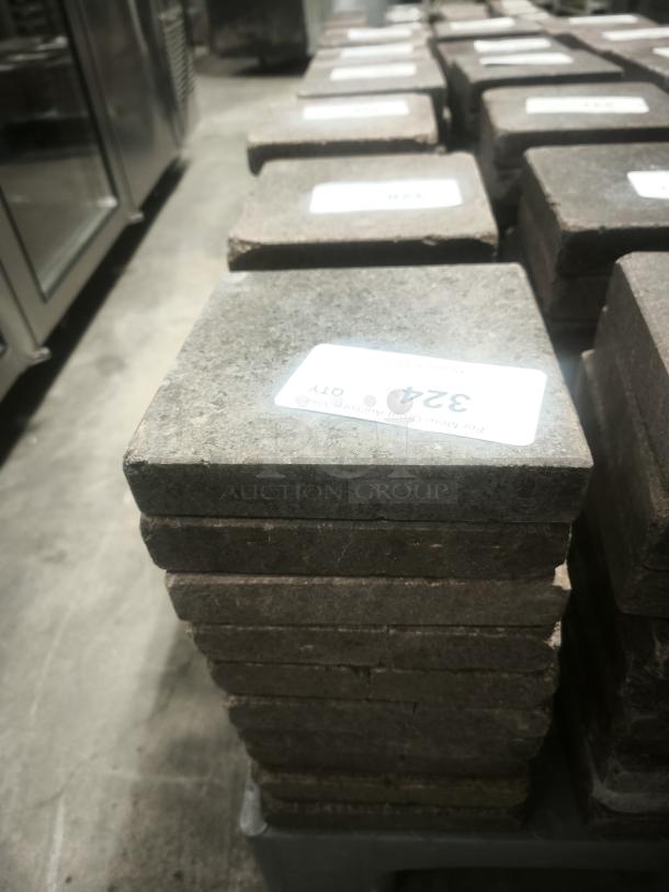 NSF certified volcanic granite slabs for cooking. Stack of square slabs with labels, suitable for food preparation.