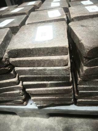 NSF Certified volcanic granite cooking slabs, stacked neatly. Each slab labeled, indicating quality and certification.