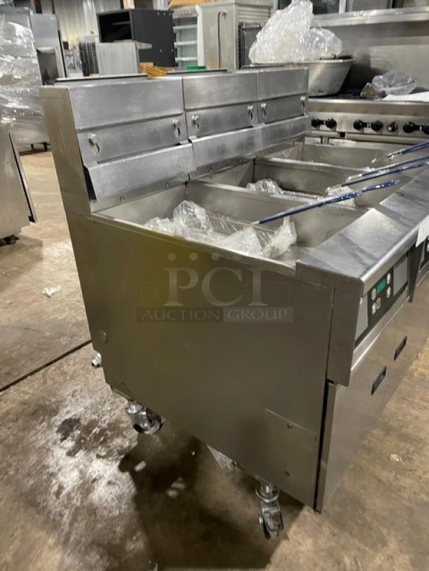 Pitco SG14-JS stainless steel 40 lb. triple-bay deep fat fryer with digital control, backsplash, basket hanger, and fry basket.