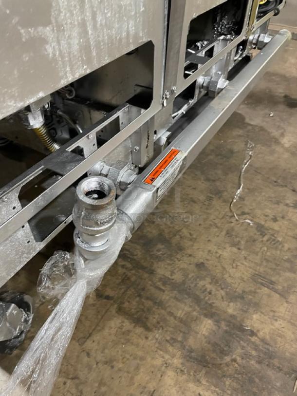 Pitco SG14-JS fryer part showing pipe connections, serial number G06H0034999, on casters, on a warehouse floor.