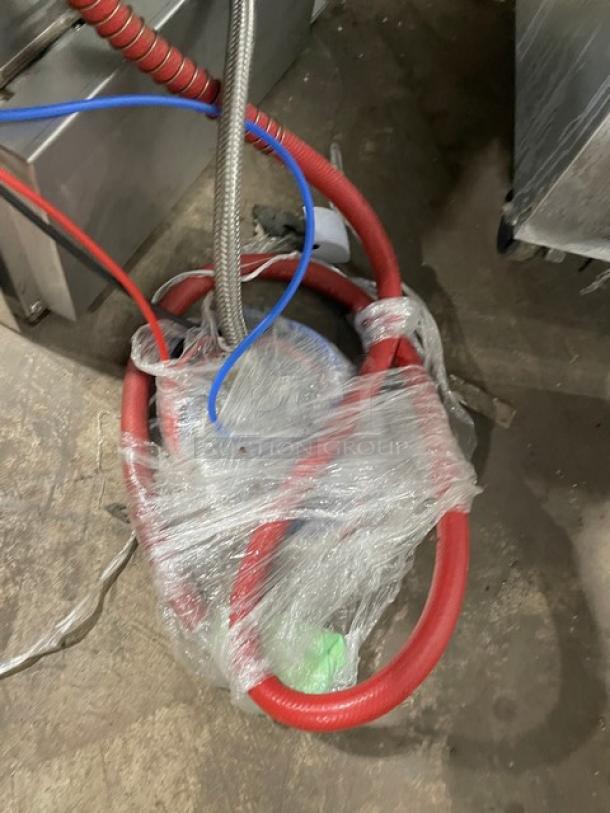 Red hoses wrapped in plastic, part of Hobart Advansys LXe Series dishwasher, model LXER. Electric, high-temp, undercounter model.