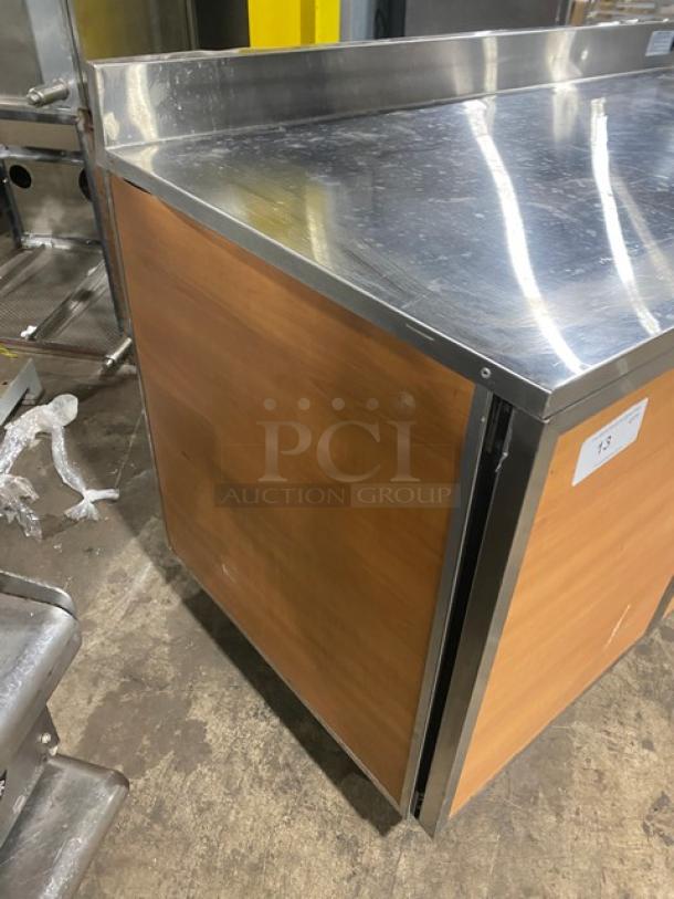 Duke Commercial Stainless Steel 2 Door 60" Worktop Refrigerator with up-turned backsplash, model RBC60M, on legs, wood panels.
