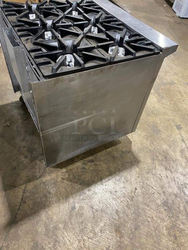 U.S. Range commercial stainless steel 6-burner gas range with enclosed storage base, on casters, in used condition.