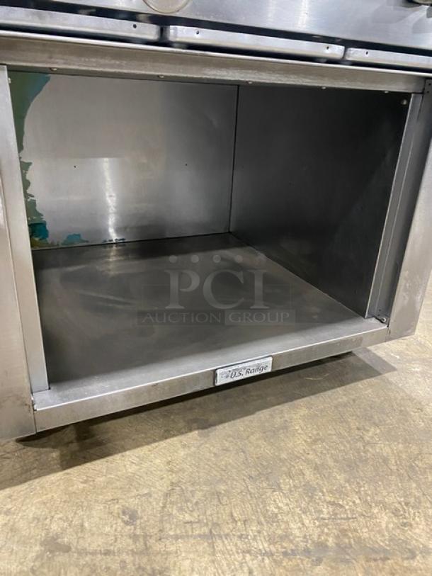 U.S. Range commercial stainless steel gas 6-burner range with enclosed cabinet-style storage, on casters, in good condition.