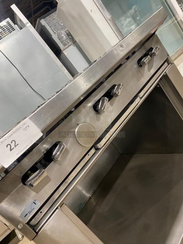 U.S. Range stainless steel 6-burner gas range with enclosed cabinet storage, on casters; controls visible, auction tag "22."