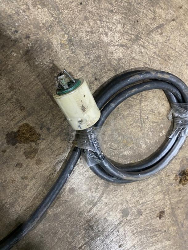 Power cord for Hobart convection oven model CN85, showing plug and coiled wire on a concrete floor.