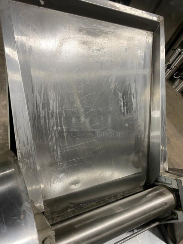 Commercial stainless steel electric dough roller/sheeter, free-standing on legs, high-speed, with visible wear and scuffs.