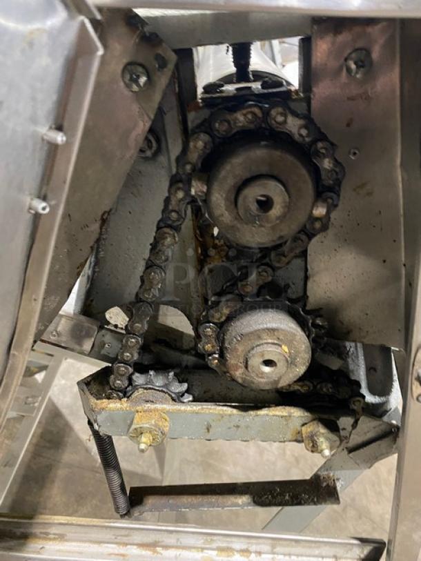 Stainless steel electric dough roller sheeter, visible gear mechanisms, on legs. Suitable for commercial use.