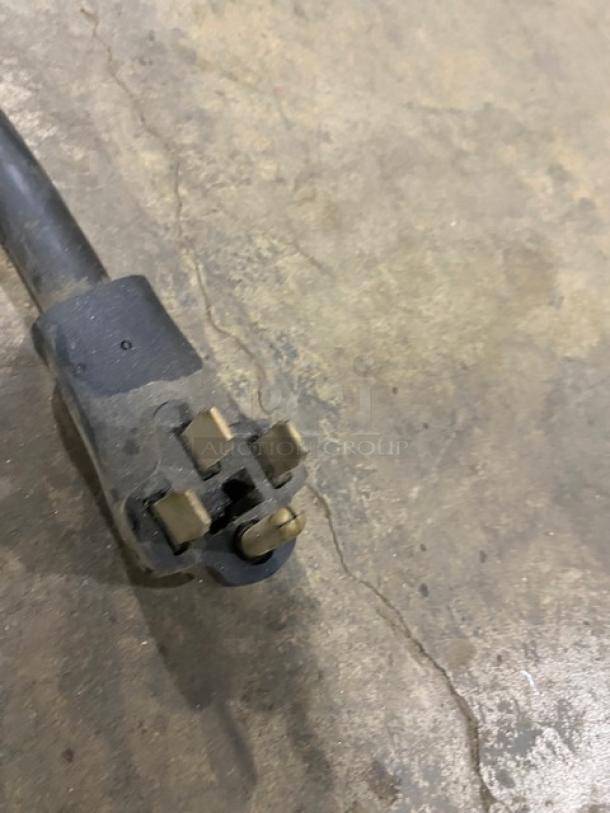 Cable connector for Bunn AXIOM22TWIN coffee brewer, showing detailed prongs and sturdy build on concrete surface.