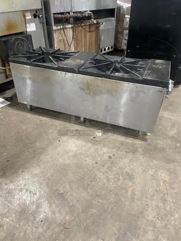 Cookline commercial stainless steel gas-powered double stock pot range on legs, visible wear, sturdy build.