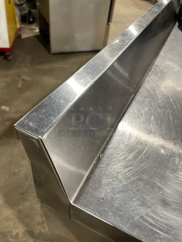 True TWT-72 stainless steel 3-door worktop refrigerator with upturned backsplash, Energy Star certified, on casters.