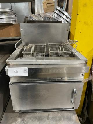 Commercial stainless steel gas-powered countertop deep fat fryer with backsplash and fry basket, good condition.