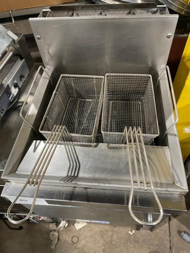 Commercial stainless steel gas-powered countertop deep fat fryer with backsplash and dual fry baskets, excellent condition.