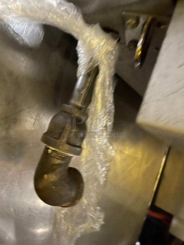 Commercial stainless steel gas-powered countertop deep fat fryer with backsplash and fry basket. Slight wear visible.