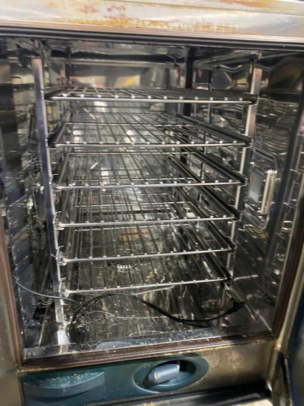 Rational SCC61 stainless steel natural gas combi convection oven, with single undershelf equipment stand and wired oven rack, used condition.
