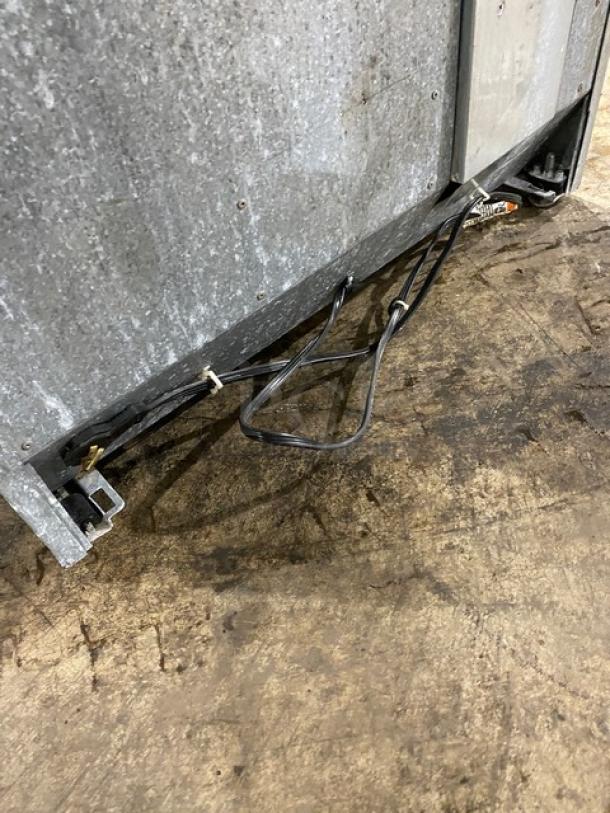 Sub-Zero 427R commercial wine cooler base with visible wiring, showing wear; stainless steel build, no labels visible.