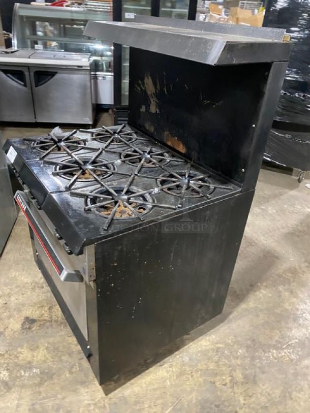 Garland commercial stainless steel gas 6-burner range/oven with backsplash, overhead salamander shelf, and wired oven rack.
