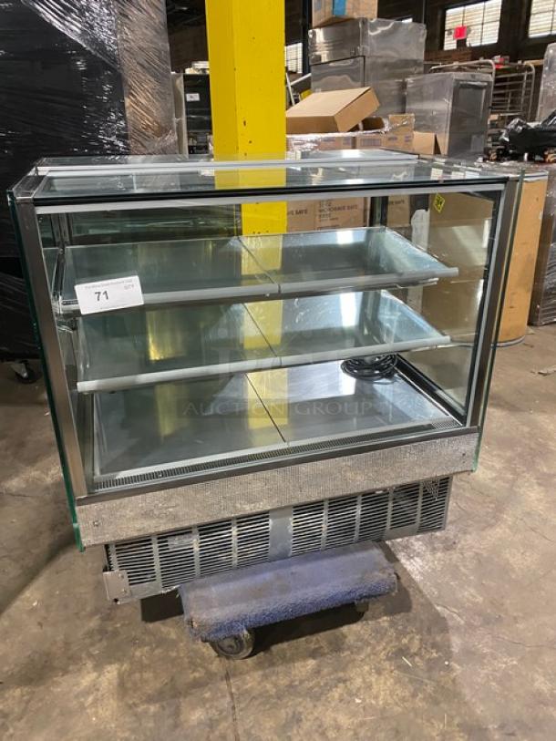 Commercial stainless steel refrigerated bakery display case with straight glass, multi-tier shelves, and rear access sliding doors.