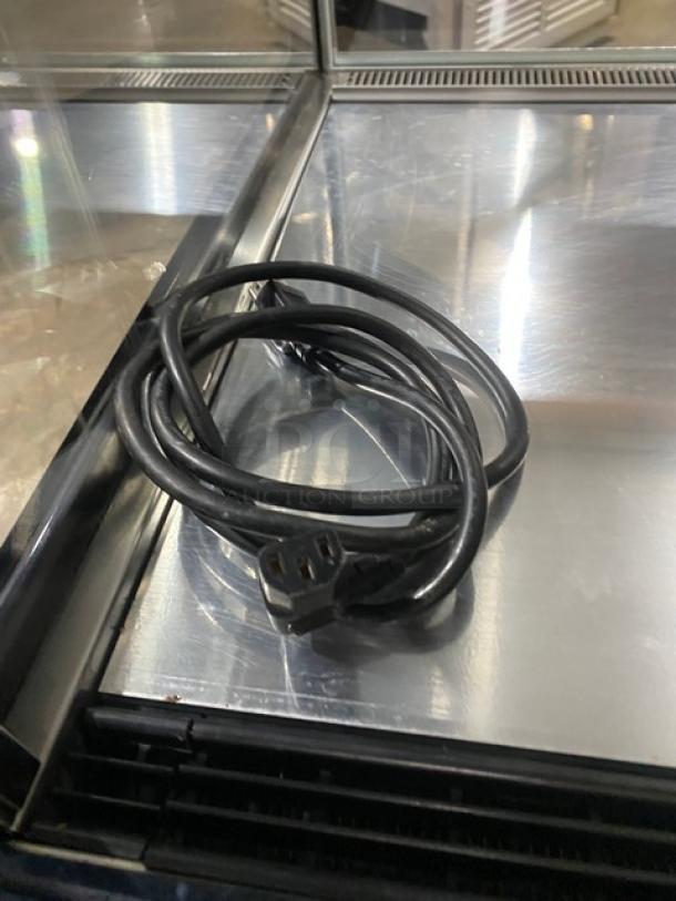 Commercial stainless steel refrigerated bakery display case with straight glass and rear access double sliding doors. Includes power cable.