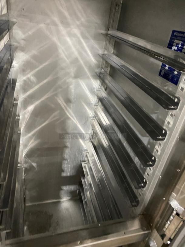 Traulsen AHT232NUT stainless steel 4-door refrigerator interior with built-in pan slides, commercial-grade, model details visible.