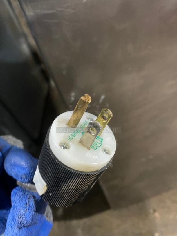 Close-up of a Traulsen refrigerator power plug, showing 115V connection for model AHT2-32NUT.