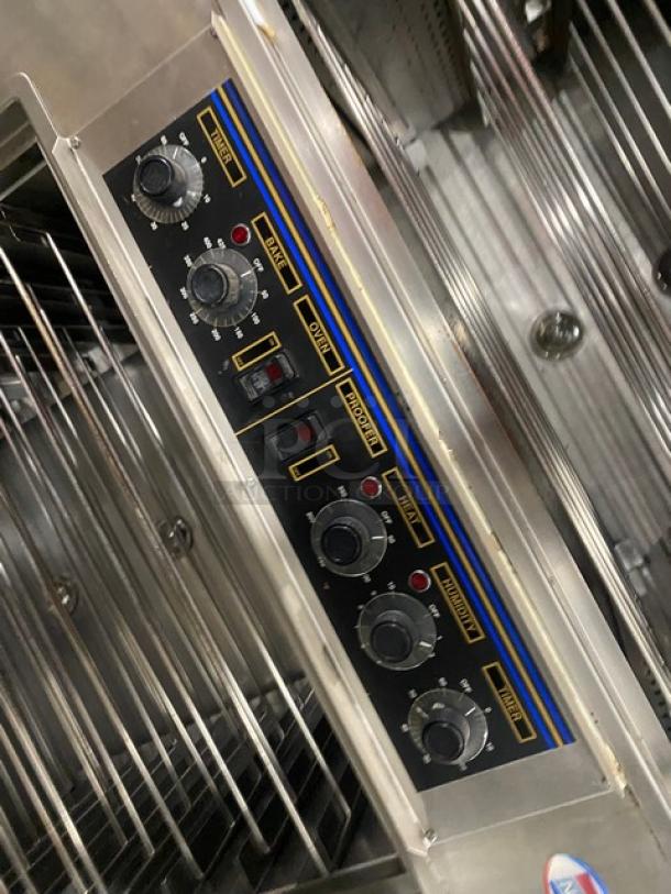 Nu-Vu SUB123 subway style commercial stainless steel double deck oven/proofer combo. Features wired racks, control panel with settings, and casters. Model SUB123 SN: 00342436060400010001, 208V 3 phase.