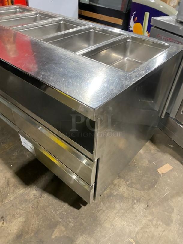 Delfield stainless steel 4-drawer refrigerated salad bar, model 18MC68PEF, with 5-well top, enclosed undershelf, on casters.