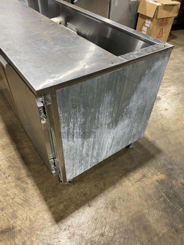 Leader stainless steel 3-door refrigerated salad/sandwich prep table with poly-coated wired rack, on casters. Shows moderate wear.