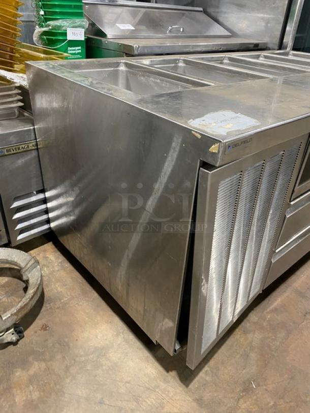 Delfield stainless steel 4-drawer refrigerated prep table, model 18MC72P13, with 5 cold wells, on casters.
