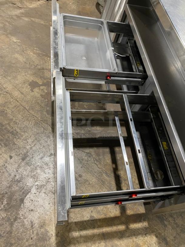 Delfield stainless steel 4-drawer refrigerated prep table, model 18MC72P13, with 5 cold wells and casters, open drawers view.