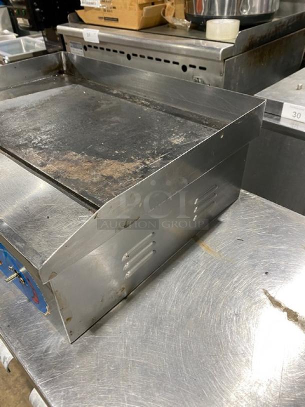 Commercial stainless steel electric flat griddle with back and side splash, visible used condition.
