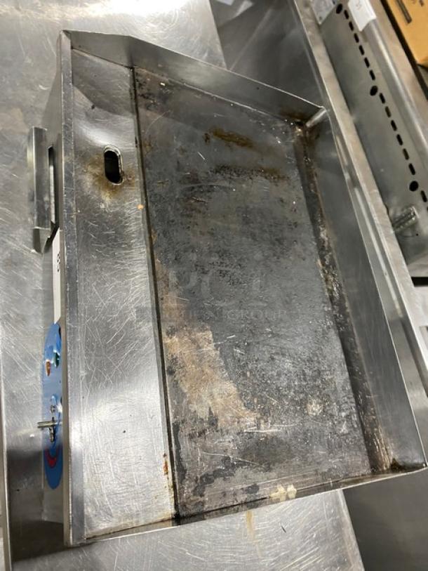 Commercial stainless steel electric countertop flat griddle with back and side splash, showing signs of wear.