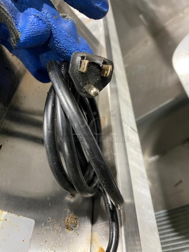 Commercial stainless steel electric countertop griddle with back and side splash, visible power cord.