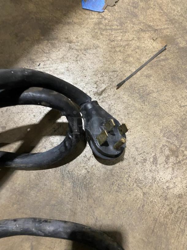 Close-up of power cord for Pitco SFSE14S fryer, featuring a 208V 3-phase plug. Cord is coiled on a concrete floor.