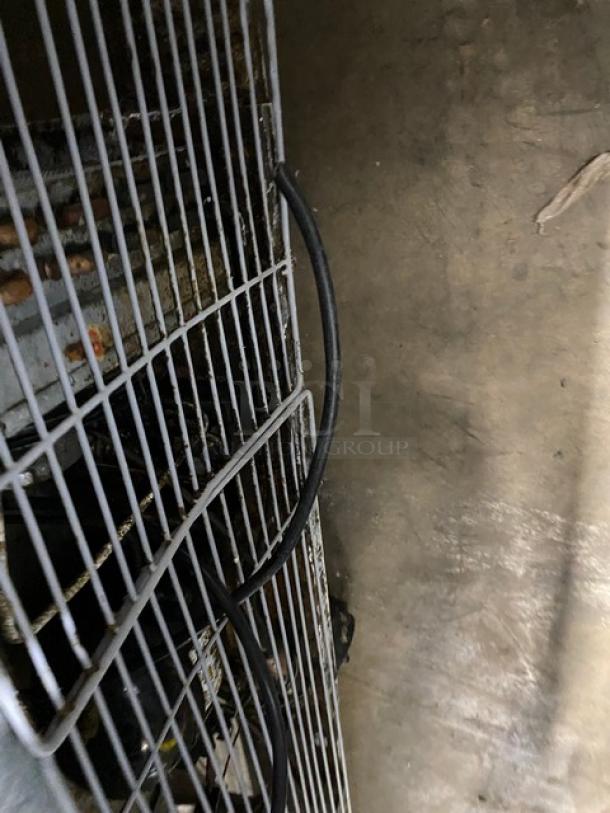 Coldline 3 Door Worktop Refrigerator with poly coated wired rack, stainless steel, on casters. Shows wear.