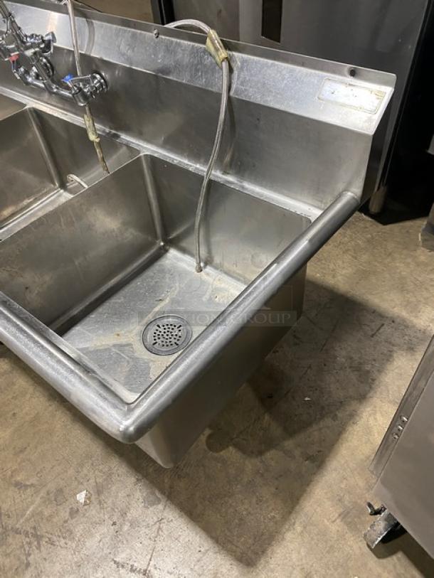 Commercial stainless steel 3-compartment dishwashing sink with backsplash, swivel faucet, jet spray attachment, and legs.