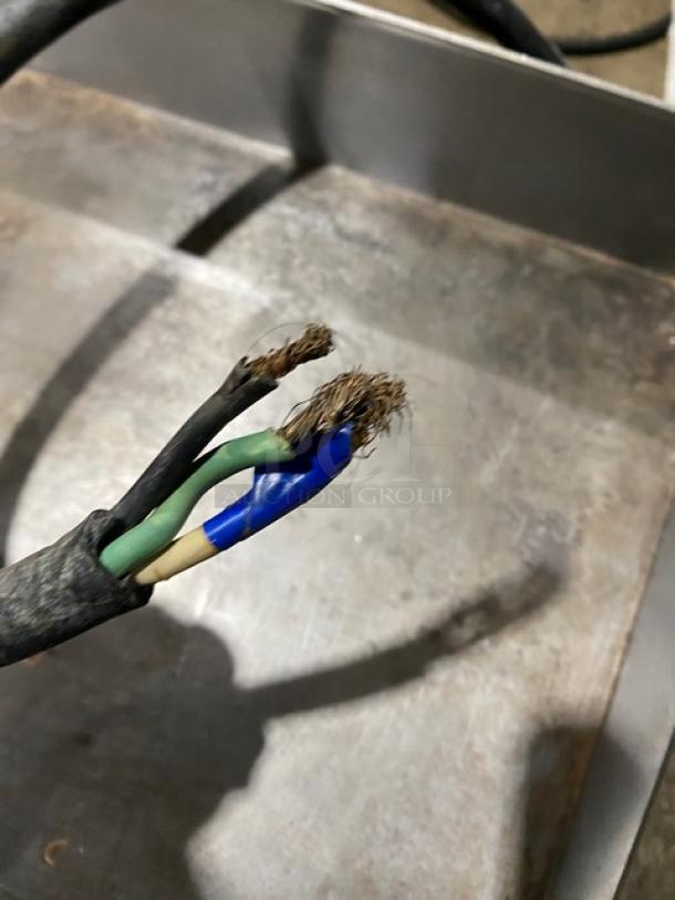 Winco Spectrum Series Model EGD-24M countertop griddle. Stainless steel, commercial grade, with back and side splash. Electric, 208/240V, on legs. Visible frayed electrical wire.