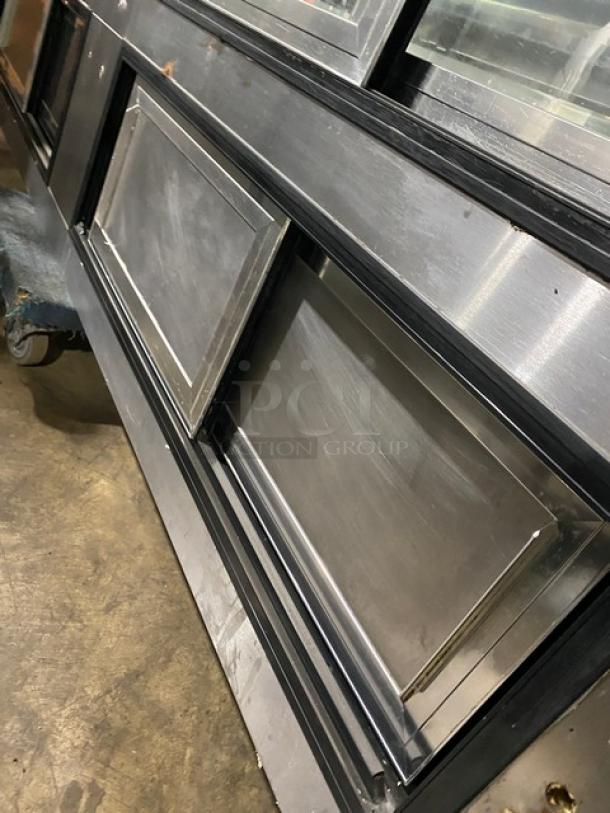 Leader NRHD96R stainless steel refrigerated meat/deli display case with curved glass, double sliding doors, and storage compartment.