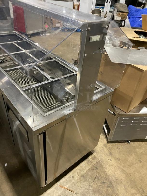 Turbo Air JBT72N stainless steel 3-door refrigerated buffet table, overhead sneeze guard, poly coated rack, on casters.