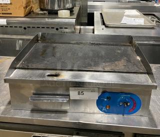 Commercial stainless steel countertop electric griddle with back and side splash, visible temperature controls; shows moderate wear.