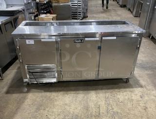 Leader Commercial Stainless Steel 3 Door Refrigerated Prep Table with poly-coated rack and casters, good condition.