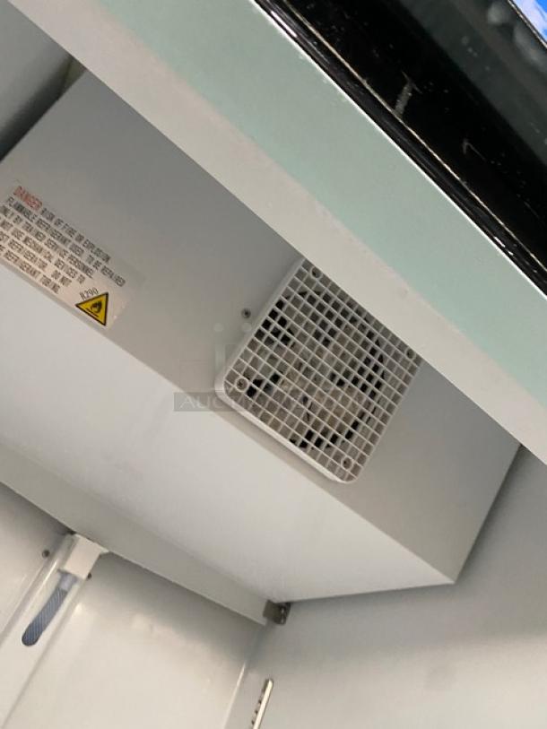 Avantco commercial refrigerator, model 178GDC23HCB, interior view with poly-coated wire rack, fan vent, on casters, 115V.