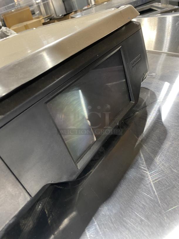 Hobart HT-Series black electric price computing scale/printer combo with stainless steel worktop. Model: HTi7LH4. Operator and customer display screen.