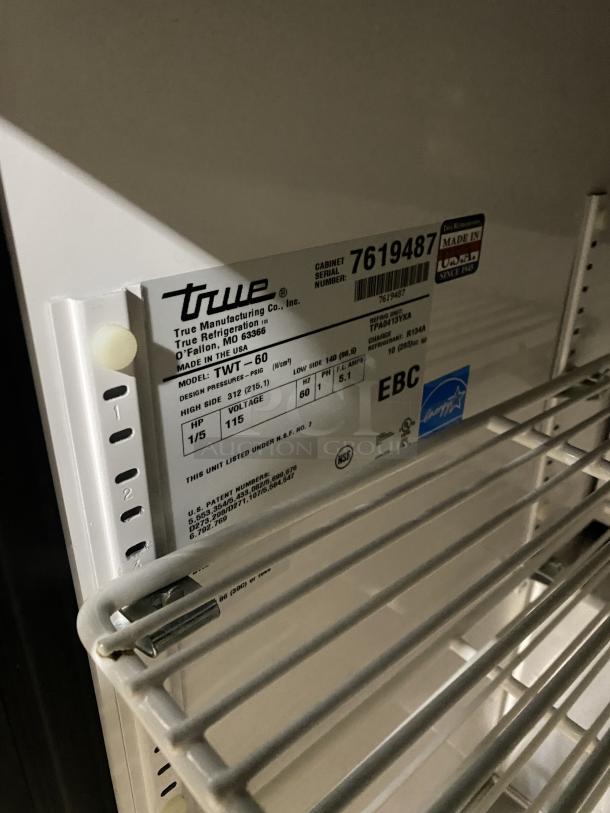 True TWT-60 stainless steel 2-door worktop refrigerator with Energy Star certification. Features poly-coated rack, backsplash, casters. Model and serial number label visible.