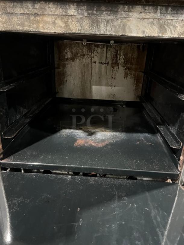 American Range commercial stainless steel 4-burner range/oven, natural gas, with backsplash, salamander shelf, on legs. Visible wear inside oven.