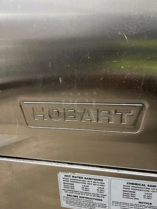 Hobart LXe Series stainless steel undercounter dishwasher, Energy Star certified, visible logo and sanitizing instructions label.