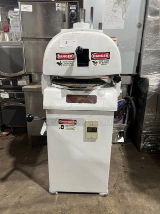 Baker's Aid commercial white semi-automatic dough divider/rounder machine on legs. Features multiple warning labels, electric powered.