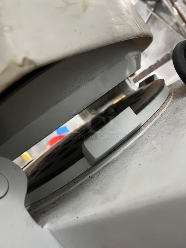 Baker's Aid semi-automatic dough divider/rounder machine in white. Floor model with legs. Close-up showing mechanical details.