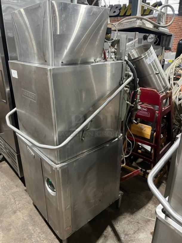 Hobart Advansys Series stainless steel door-type ware washer on legs, electric powered, commercial use, visible in used condition.